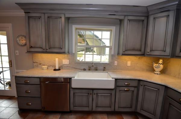 Distressed blue-gray cabinetry w/ a glaze. Full-height marble backsplash matching the countertop. Fun kitchen!