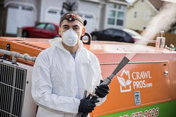 Crawl Pros technician smiles beneath mask.