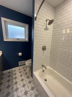 3 x 6 subway shower tiles to the ceiling add height to this 50s Chicago ranch shower...and the wall also cleverly hides the toilet.