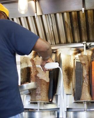 Carving the beef and lamb gyro cones