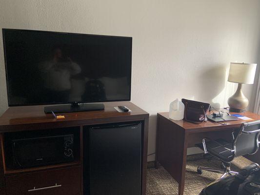 TV and desk along with the mini fridge and microwave in 116.