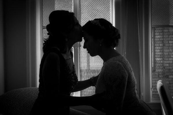 Silhouette, Mother of the bride kissing her daughter prior to ceremony