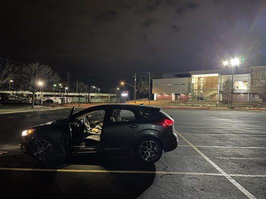 Parking lot with high school in back