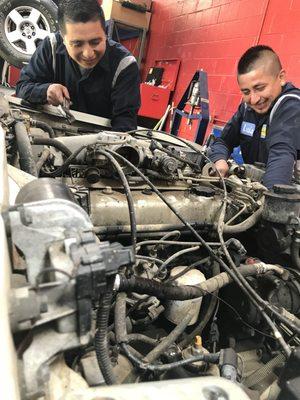 enjoying what they do while removing an engine out of a 91 Toyota Landcruiser