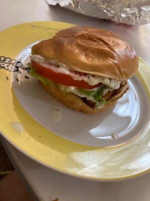 Fish sandwich unwrapped on a plate at home.