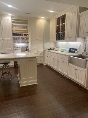 Craft Room with custom cabinetry, easy close drawers, hidden trash cans, large granite island and surround with a farmhouse sink.