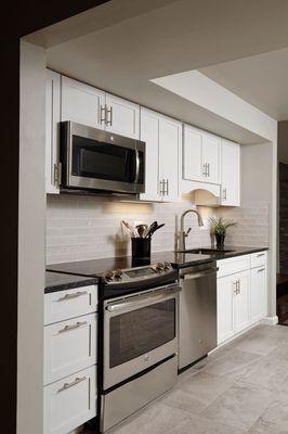 Updated Kitchen-New white shaker cabinets and new appliances with tile flooring. Are you ready to cook? *Real FTC Interiors Re-design