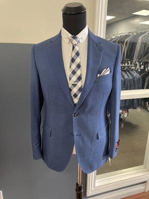 Royal blue pindot fabric with white club collar shirt, silver tie bar, gingham blue tie and blue piped white pocket square.