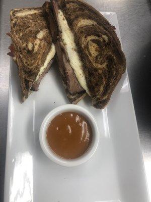 Brisket sandwich with mozzarella on toasted rye served with a golden bbq sauce.