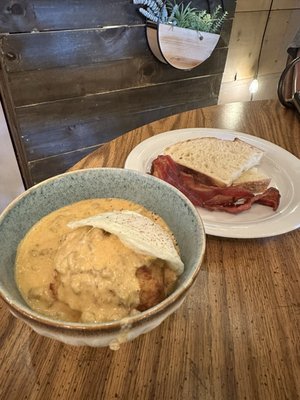 Biscuits and gravy with sides of bacon and sourdough