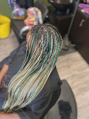 Small knotless braids with triangle parts, thigh length.