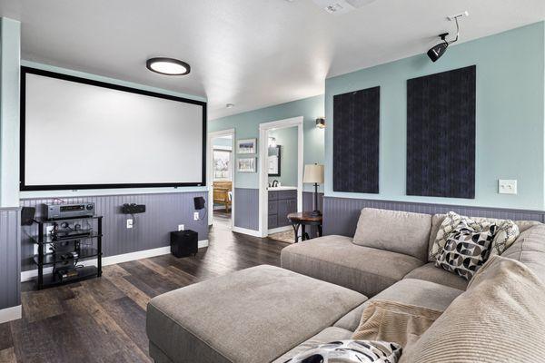 A room designed for epic movie nights with a projector and a huge screen.