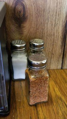 Cajun seasoning on the table for adding the needed kick.