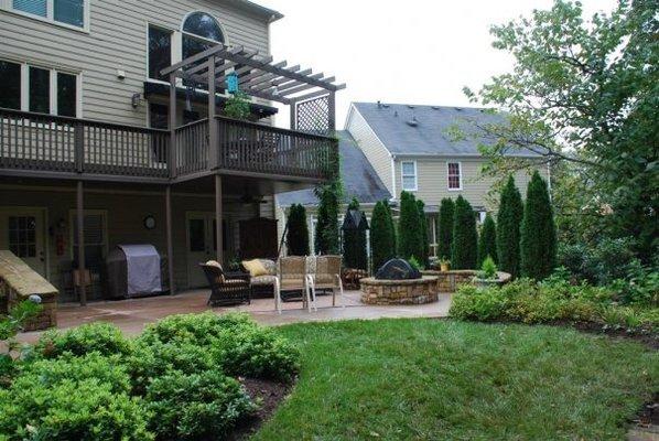 Award winning landscape design by The Inspired Garden, tinted concrete/flagstone border, patio, firepit, stack stone seat wall, garden.