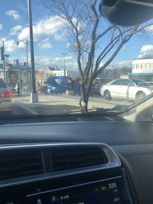 Trash can (facing main thoroughfare) overflowing with trash, per usual