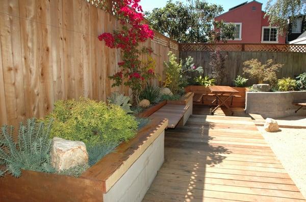 The whole retaining wall on this side of the space is a bench,below is a dining area with a custom made salvaged redwood table...