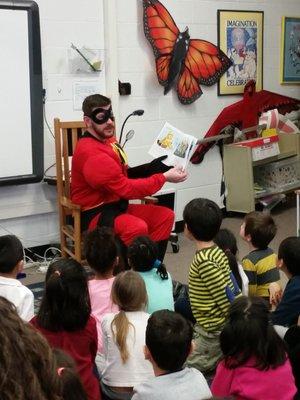 Donation of new books and delivered by a group of "superheroes" and story time provided