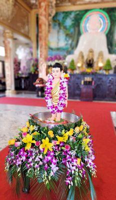 Bathing baby Prince Siddhartha with holy water using the ladle is meant to purify one's mind and body.