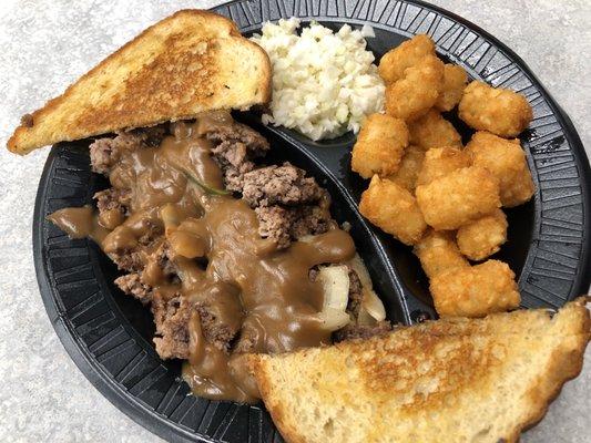 Hamburger steak with gravy, onions, tater tots and slaw and Texas Toast