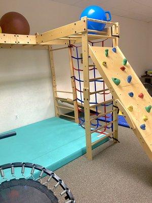 One of two of our gyms. Has a rock wall, monkey bars, square rope climbing wall, and a scooter board ramp.