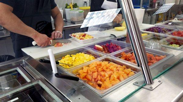 Fresh fruits being prepped for the morning - apples and bananas sliced to order to avoid oxidation.