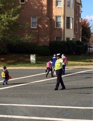 Kids walking home and officer stopping cars