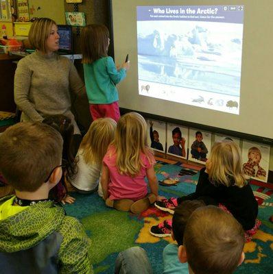 Preschoolers learning through technology on an interactive whiteboard.