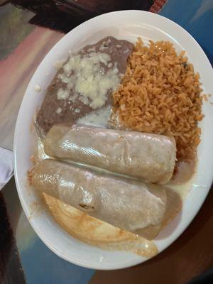 Chicken enchiladas with rice and beans and cheese sauce instead of the verde