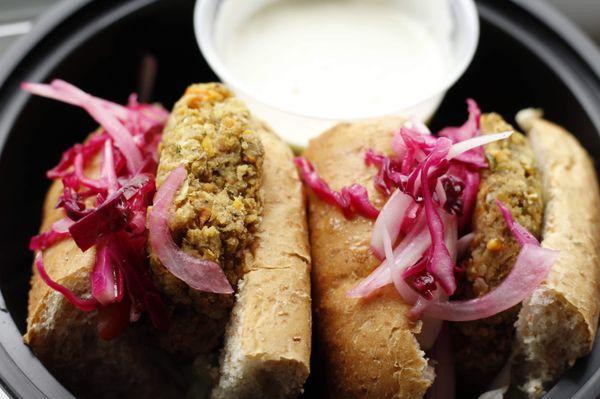 Garbanzo veggie patty sliders w/ pickled onions & red cabbage on whole wheat bread and garlic aioli.