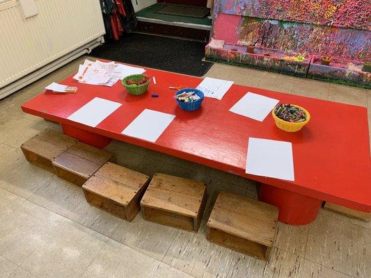 Art table (made from a recycled door!) We sit on handmade stools.