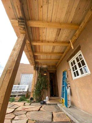 A Timber frame porch consisting of 12x12" posts with corbels, 12x6" beams with lap joints, a 12x6" ledger and 8x8" rafters