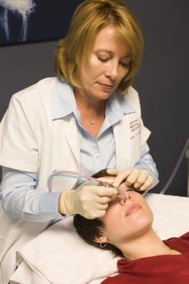 Denise performing a microdermabrasion.