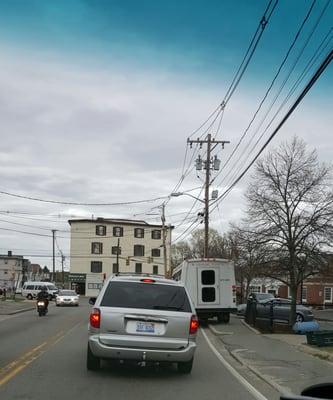 This van was in front of me at a red light on Oak St in Brockton They pulled onto the sidewalk and almost hit the grey car.