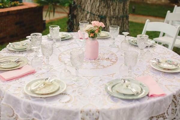 Vintage Battenberg overlay on pink tablecloth with mix match vintage plates and painted mason jar for centerpiece. Beautiful!