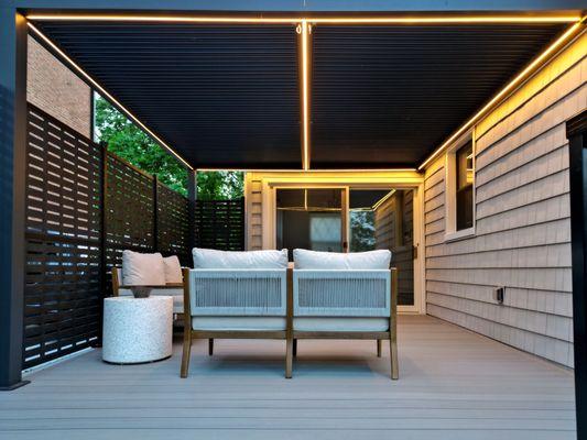 Cozy covered seating area with modern lighting on the deck in Bayside, perfect for relaxing evenings, designed by Vandeck Builders.