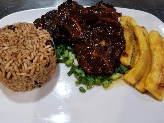 Oxtail with Rice and Beans with a side of plantains (typically served with Cabbage or Salad not pictured here).