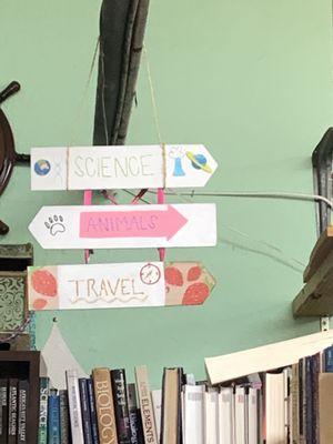 Signage directing shoppers to science, animals, travel sections of bookstore