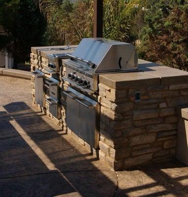 BBQ  With  colored poured in place concrete counter top  stone veneer & stainless steel 4 burnet grill with stainless steel a...