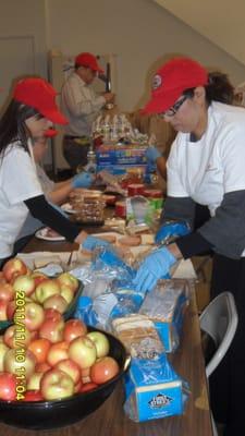 Team Cars 4 Causes preparing sack lunches for Catholic Charities.