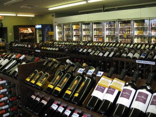 three rows, stacked of wine bottles separated by regions