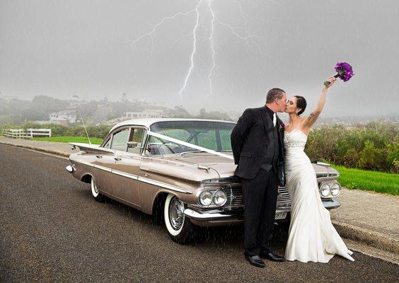 Rainy day wedding - a couple is posing during lightning - captured by panorama city wedding photographer.