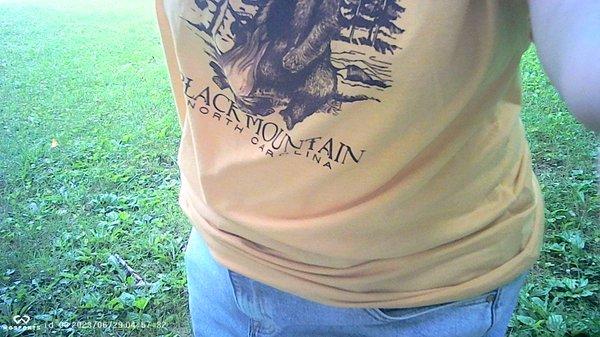 researcher Mary Hollowell wears a t-shirt from Take A Hike Mountain Outfitters in Black Mountain, NC while checking a Wosports trail cam