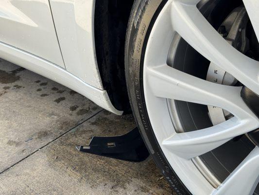 Broken mud flap, torn off by the car wash machine.