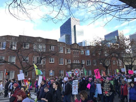 2017 Women's Rights' March in foreground at 4th & Bell facing east, Charlesgate Apartments, Amazon looming in the distance.