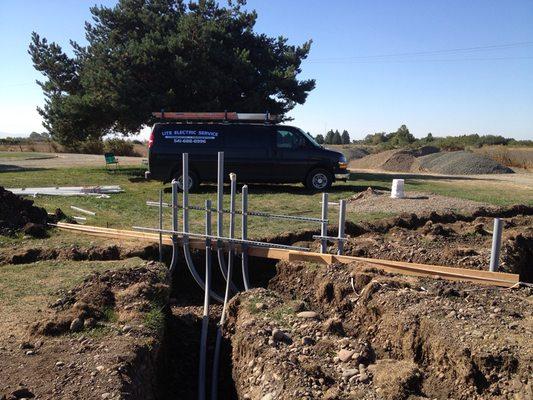 Picture of an underground rough in for a 3 phase 600amp service for a brood farm and one of our work vans