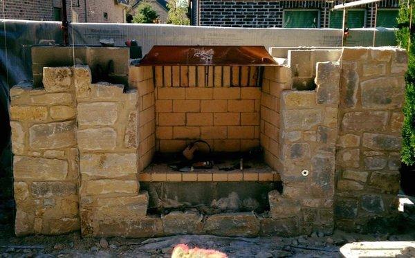 Outdoor fireplace constructed with stone and brick.