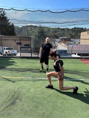 Coach Mike guiding client with walking lunges. Personal training.