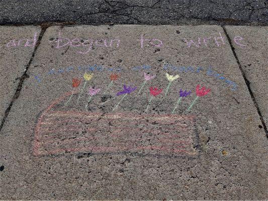 "I turn coffins into flowerbeds," taken from a song sung at the church, written on NCF's sidewalk in chalk on Sunday, April 24, 2022.