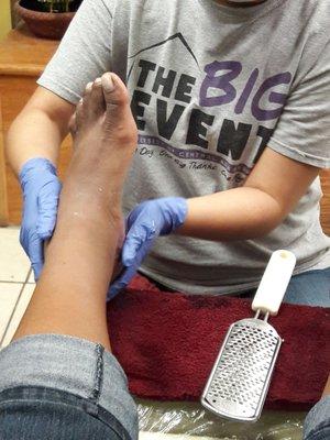 Man, sloghing off calluses--with a cheese grater!