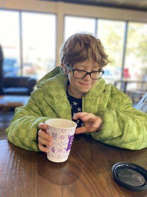 Just a cute little dude in a Minecraft coat enjoying some hot chocolate.